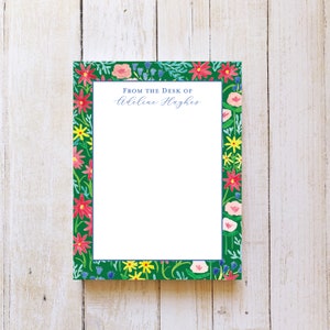 May include: Floral notepad with a green background and a border of colorful flowers. The text "From the Desk of Adeline Hughes" is printed at the top.