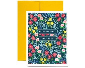 May include: A greeting card with a floral pattern in shades of pink, yellow, blue, and green on a dark blue background. The text "Brighter Days Are Ahead" is printed in white on a white rectangle.