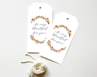 May include: Two white gift tags with a fall-themed wreath and the text "So very thankful for you!" printed in black calligraphy.