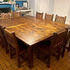 May include: A large, rectangular, wooden dining table with a dark brown stain. The table is surrounded by eight chairs with a similar dark brown stain. The chairs have a slatted back and a solid seat.