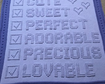 Puede incluir: Una manta de bebé de crochet de color morado y blanco con las palabras "Cute", "Sweet", "Perfect", "Adorable", "Precious" y "Lovely" en un estilo de casilla de verificación.