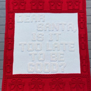 May include: White crochet blanket with a red border. The blanket has the words "Dear Santa Is It Too Late To Be Good?" in white yarn.