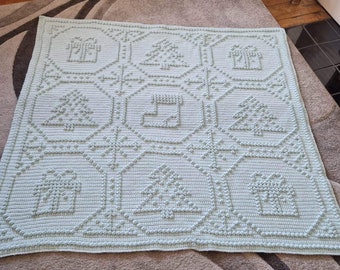 May include: A light blue crocheted blanket featuring a repeating pattern of Christmas trees, houses, and stockings. The blanket is made with a textured stitch, giving it a raised, puffy appearance.