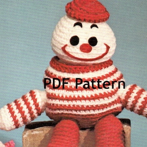 May include: Crochet pattern for a red and white striped clown doll with a red hat. The pattern is available as a PDF download.  PDF Pattern