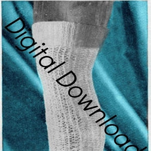 May include: A close-up of a white knitted stocking with a lacy pattern. The stocking is on a blue background.