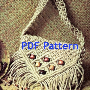 Puede incluir: Bolso de hombro de macramé beige con flecos en la parte inferior y cuentas de madera. El bolso presenta un patrón de diamantes con cuentas de madera y el texto "PDF Pattern" en azul.