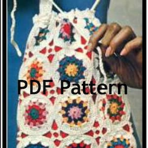 以下が含まれることがあります： 手作りのかぎ針編みバッグ。巾着開閉式で、赤、青、黄、ピンクなどのカラフルな花柄モチーフのパッチワークデザインが特徴です。「PDF Pattern」の文字がバッグに表示されています。