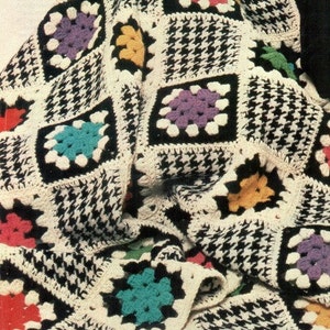 May include: A crochet blanket with a black and white houndstooth pattern and colorful granny squares. The blanket is folded and has a fringe border. The text "PDF Pattern" is visible at the bottom of the image.