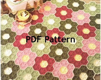 May include: A crochet blanket with a hexagonal pattern in shades of pink, green, and red. The blanket is made up of individual flower-shaped motifs. The text "PDF Pattern" is printed in the center of the blanket.