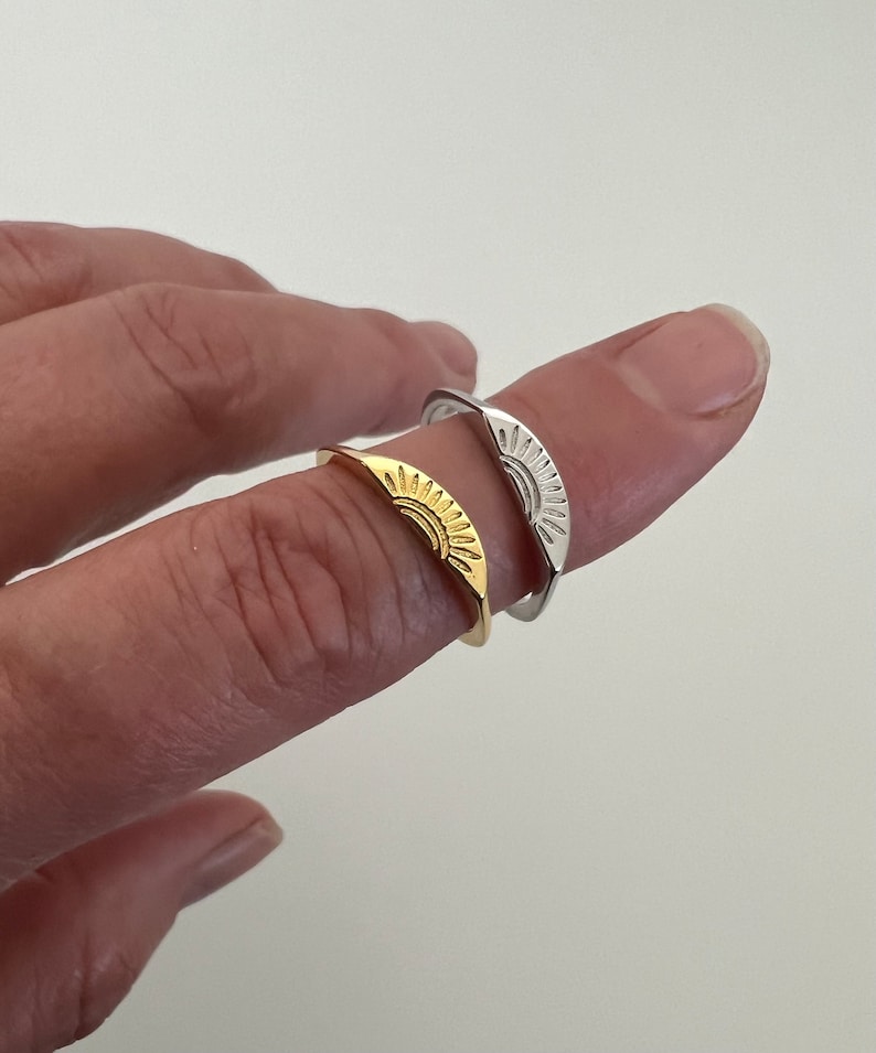 May include: Two adjustable rings with a sun design. One ring is gold and the other is silver.
