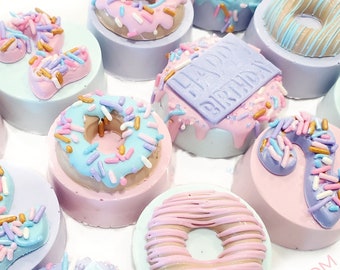 May include: A collection of nine decorated donut-shaped cookies with sprinkles and frosting. The cookies are decorated with the words "Happy Birthday" and "Daddy Birthday".