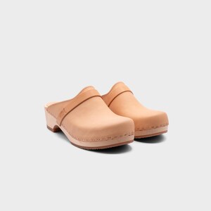 Malmö-style clogs designed by Sandgrens in classic Ecru Beige  leather. Featuring a smooth, slip-on design with a supportive strap for stability. The sturdy wooden sole and hand-stapled construction ensure durability and all-day comfort, making them a stylish and functional footwear choice.