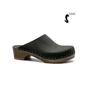 May include: Black leather clog with a wooden heel and a white stitch detail around the sole.