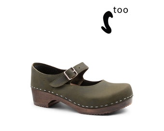 May include: Olive green leather clog with a buckle strap and a wooden heel. The clog has a white stitch detail around the sole.