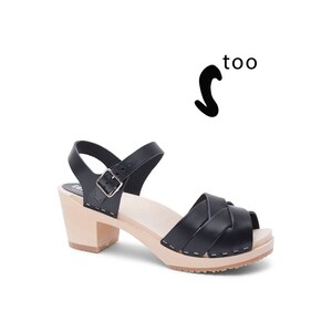 Puede incluir: Sandalias de tac&oacute;n de cuero negro con dise&ntilde;o de tira tejida y suela de plataforma de madera.