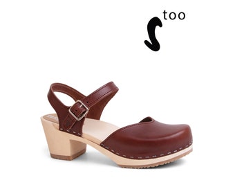 May include: Brown leather heeled clog with a buckle strap and an open toe.