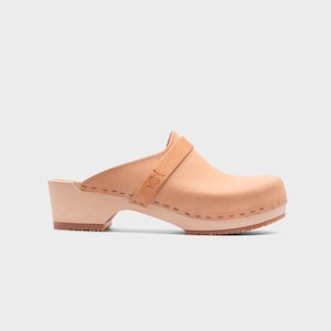 Malmö-style clogs designed by Sandgrens in classic Ecru Beige  leather. Featuring a smooth, slip-on design with a supportive strap for stability. The sturdy wooden sole and hand-stapled construction ensure durability and all-day comfort, making them a stylish and functional footwear choice.