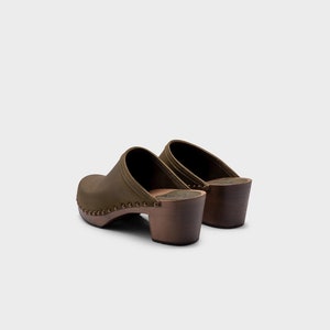 High heel studded clog mules with Olive green nubuck leather and dark brown wooden base.