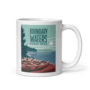 May include: White ceramic mug with a colorful illustration of a canoe on a lake. The text "Boundary Waters Canoe Area" is printed on the mug.