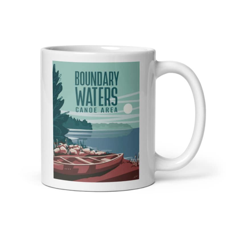 May include: White ceramic mug with a colorful illustration of a canoe on a lake. The text "Boundary Waters Canoe Area" is printed on the mug.