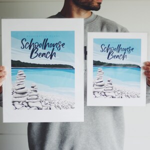 May include: Two prints of a beach scene with a stone cairn in the foreground. The prints are titled "Schoolhouse Beach" and are in a retro style.