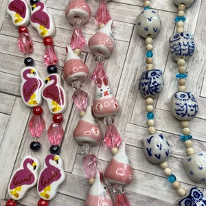 Blue and white ceramic owl, pink flamingos, pink rabbit bead strands
