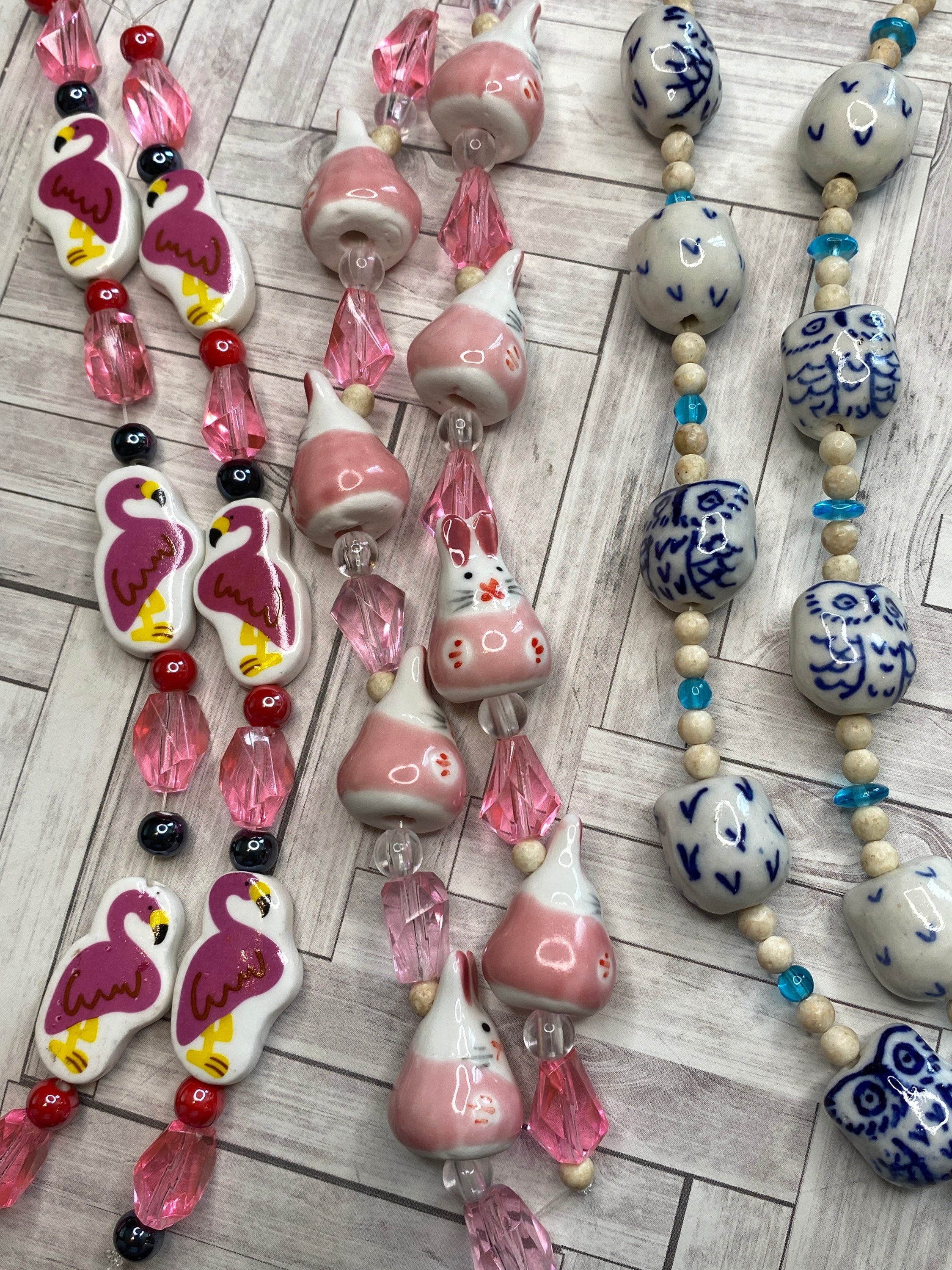 Blue and white ceramic owl, pink flamingos, pink rabbit bead strands