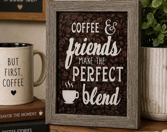 May include: A rectangular wall sign with a weathered gray wood frame featuring a background of dark brown roasted coffee beans. The white text reads COFFEE & friends MAKE THE PERFECT blend with a small white coffee cup icon below the text.