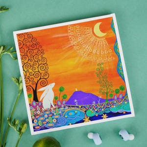 May include: A square canvas print featuring a white rabbit in a landscape with a purple hill, orange sky, and a yellow crescent moon. The scene includes stylized trees, colorful circular patterns, and swirling blue water elements at the bottom.