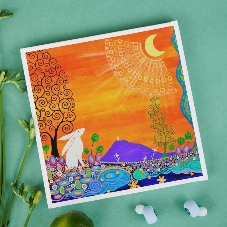 May include: A square canvas print featuring a white rabbit in a landscape with a purple hill, orange sky, and a yellow crescent moon. The scene includes stylized trees, colorful circular patterns, and swirling blue water elements at the bottom.