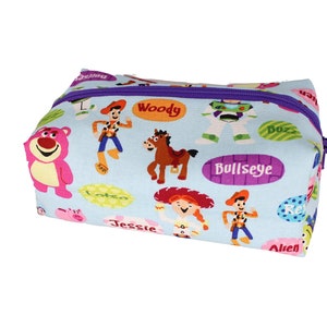May include: A light blue zippered pouch with a Toy Story theme. The pouch features characters such as Woody, Buzz Lightyear, Jessie, and Bullseye. The pouch is decorated with colourful cartoon images and text.