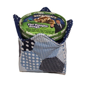 May include: A blue and white fabric ice cream container holder with a hexagonal pattern. The holder is holding a pint of Ben & Jerry's non-dairy The Tonight Dough ice cream.