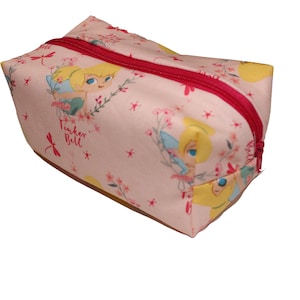 Könnte beinhalten: Rosa durchsichtige Tasche mit Reißverschluss und Tinkerbell-Motiv. Die Tasche hat ein sich wiederholendes Muster aus Tinkerbell, Blumen und Libellen. Der Text "Tinker Bell" ist auf der Tasche aufgedruckt.