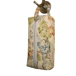 Può includere: Una pochette con zip a tema Winnie the Pooh con sfondo bianco e illustrazioni colorate di Winnie the Pooh e i suoi amici. La pochette ha una zip blu chiaro e una maniglia argentata.