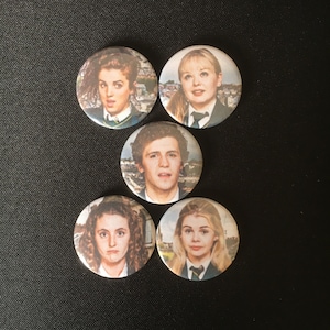 May include: Five round buttons with images of people from the movie 'The Inbetweeners'. The buttons are white with a black border and feature images of the four main characters from the show.
