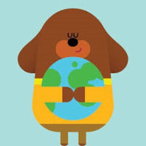 Op de afbeelding: Een cartoon illustratie van een bruine hond die een blauwe en groene wereldbol vasthoudt. De hond heeft een geel shirt en bruine armen en benen. De hond heeft een zwarte neus en ogen en een kleine glimlach.
