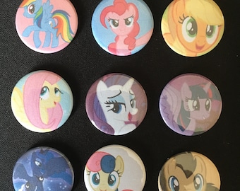 Può includere: Dieci bottoni rotondi e colorati con immagini di cartoni animati dei personaggi di My Little Pony. I personaggi sono Twilight Sparkle, Pinkie Pie, Rainbow Dash, Fluttershy, Rarity, Applejack e Spike.