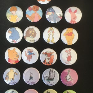 May include: A set of 18 Winnie the Pooh character buttons. The buttons are round and feature various characters from the Winnie the Pooh stories, including Winnie the Pooh, Piglet, Tigger, Eeyore, Owl, Kanga, Roo, Rabbit, and Christopher Robin. The buttons are colorful and feature a variety of different backgrounds.