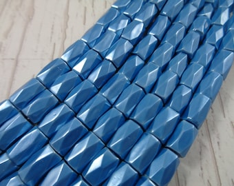 May include: A strand of light blue faceted glass beads. The beads are rectangular in shape and have a metallic sheen.