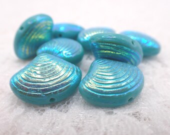 May include: A selection of iridescent turquoise seashell-shaped beads. The beads have a glossy finish and are designed with detailed ridges. These beads are ideal for jewellery making and crafting projects.