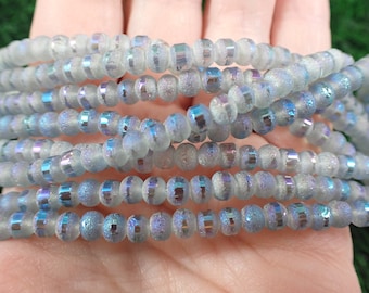May include: A strand of iridescent glass beads with a frosted finish. The beads are light blue with a subtle shimmer.