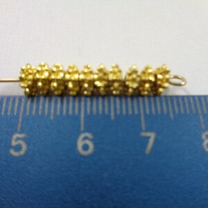 May include: A gold-colored metal bead chain with a loop at the end, measuring approximately 1 inch in length. The chain is made of small, round beads that are clustered together.