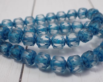 May include: A strand of blue glass beads with a frosted finish. The beads are faceted and have a starburst design.
