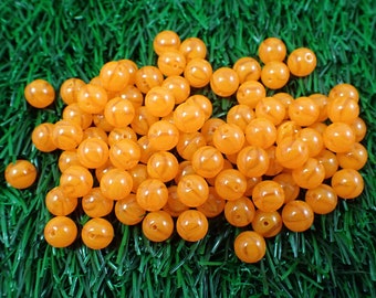 May include: A pile of orange swirl beads, perfect for crafting or jewelry making.