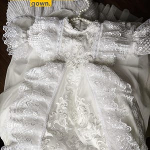 May include: A white gown with detailed lace and a pearl necklace. The gown has lace sleeves and a flowing skirt. The image text reads, "There is a listing made for This particular white gown."