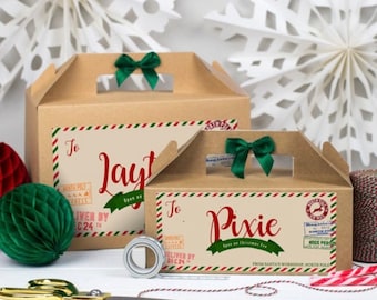 May include: Two brown cardboard gift boxes with green bows and labels that say "To Jayt" and "To Pixie". The boxes are decorated with red and green stripes and have a white paper snowflake in the background.
