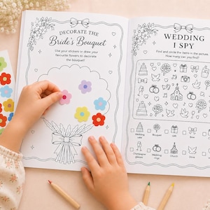 May include: An activity book with two open pages featuring a 'Decorate the Bride's Bouquet' section with a flower outline and a 'Wedding I Spy' game. A sheet of colourful flower stickers is included to place on the bouquet illustration.