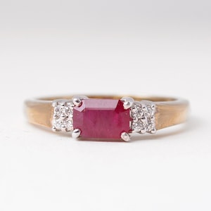 Peut inclure: Une bague en or avec une pierre précieuse en rubis rouge et de petits diamants sertis dans la bande.