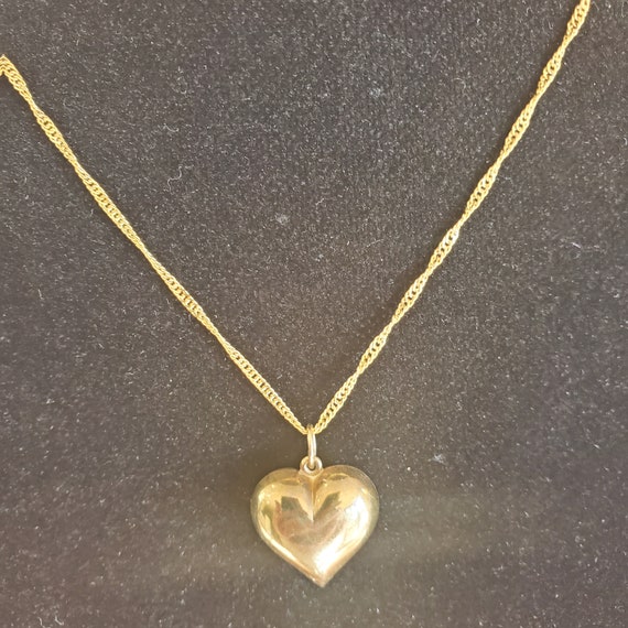 Gold puff heart on gold necklace.