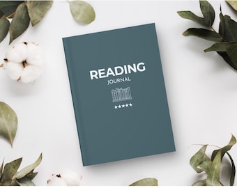 Puede incluir: Un diario de lectura de color verde azulado con las palabras "READING JOURNAL" en blanco. La portada presenta un gráfico de pilares y cinco estrellas. El diario está rodeado de algodón y vegetación sobre un fondo blanco.